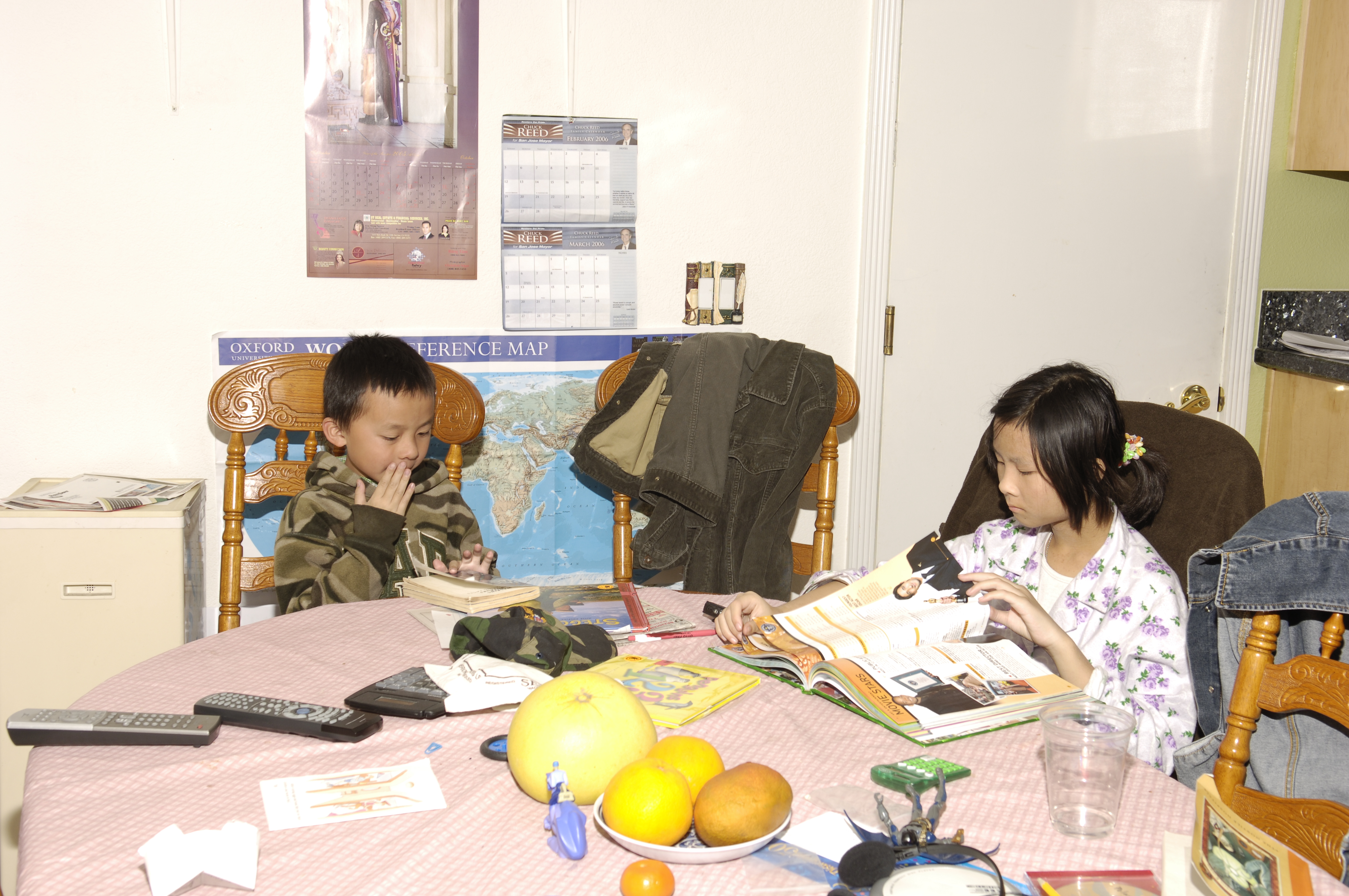 A photo of me and my sister as children as we dive into books we're about to read at the dining table in our old childhood home.