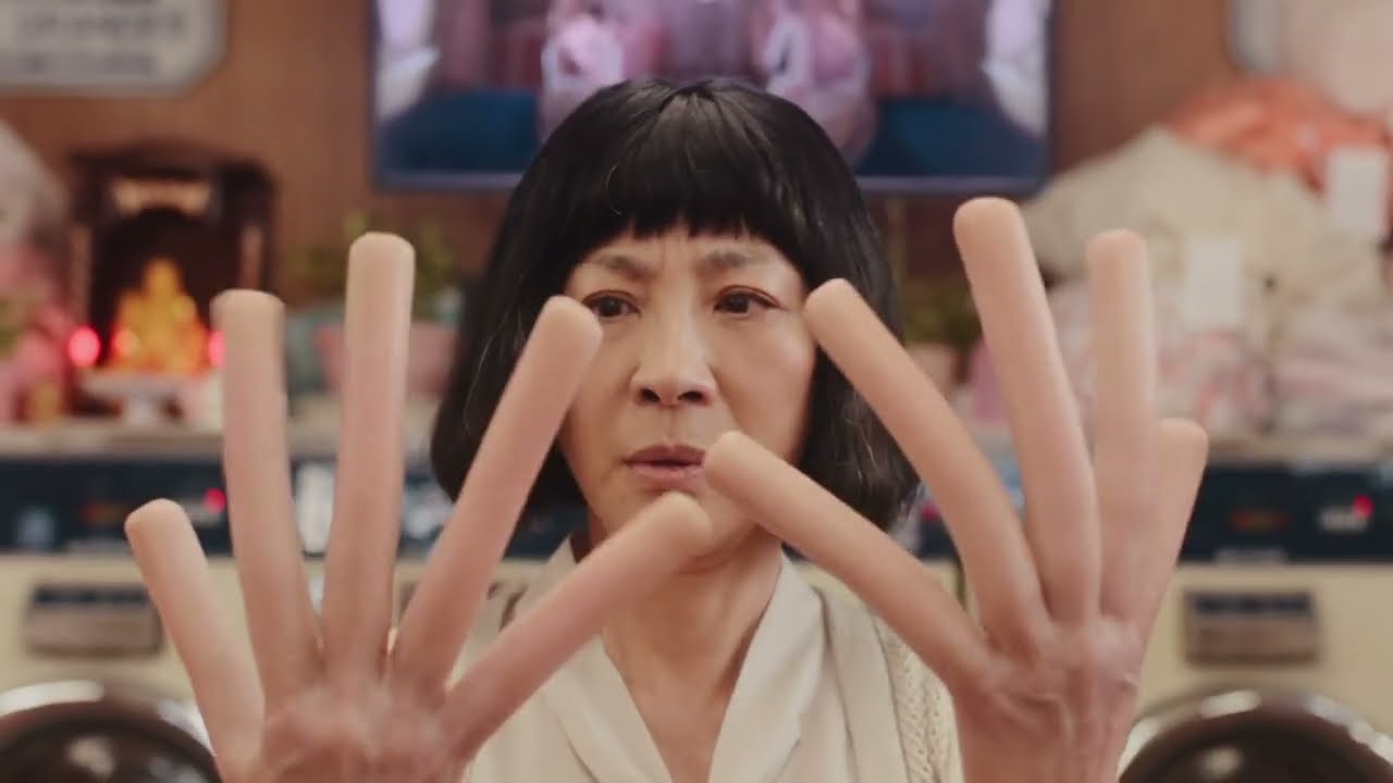 A picture of an Asian woman looking at her extremely long and rubbery long fingers where each finger looks like a long sausage  as seen in the movie 'Everything Everywhere All at Once'.
