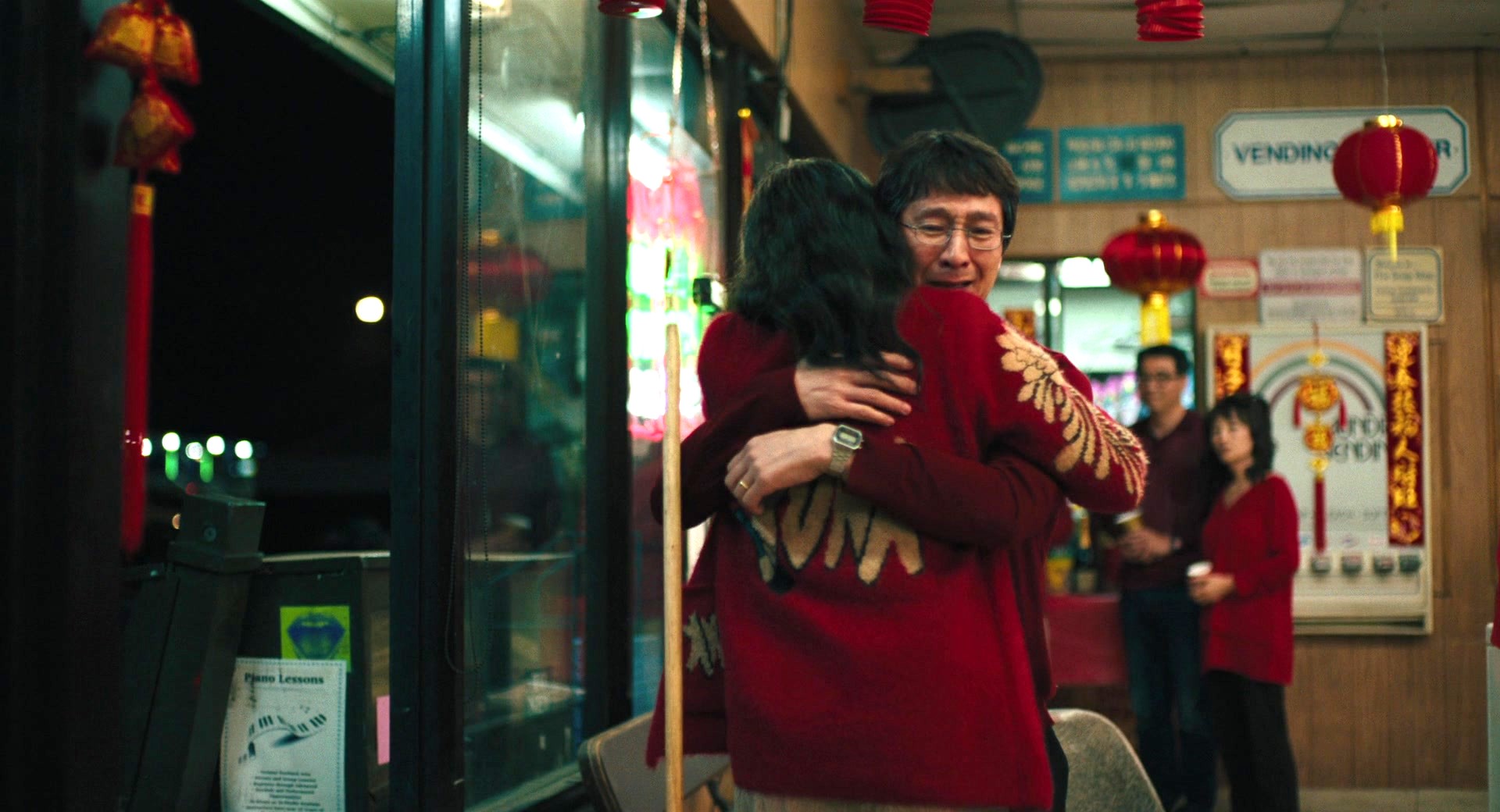 A picture of an Asian man hugging a woman in a laundromat  as seen in the movie 'Everything Everywhere All at Once'.